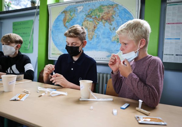 Drei Schüler testen sich unter der Aufsicht ihrer Lehrerin auf das Coronavirus. In weiterführenden Schulen in NRW testen sich Schüler und Mitarbeiter drei Mal pro Woche. - © picture alliance