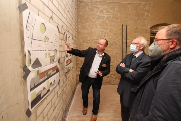 Arne Brand (links) und Jörg Düning-Gast (rechts) vom Landesverband erläutern Kreistagsmitglied Dr. Bernd Groeger in der Domäne am Schloss Brake die Umbaupläne. - © Jens Rademacher