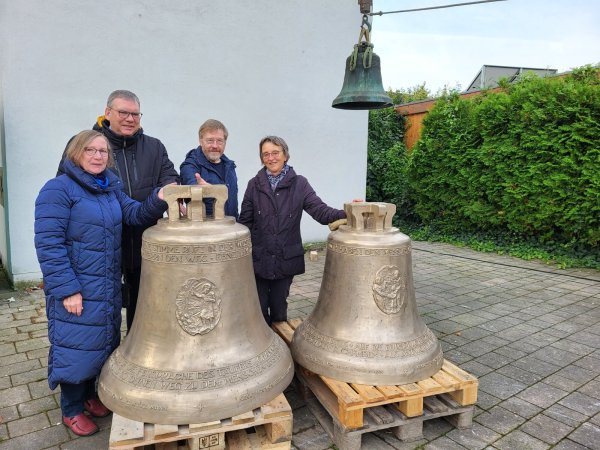 Dagmar Hense, Vorsitzende des Pfarrgemeinderates, Gemeindereferent Franz-Herbert Hense, Hubert Sprint, Förderverein in Liebfrauen und Karin Plöger vom Pfarrgemeinderat (von links) umfassen die neuen Glocken für den Turm der Liebfrauenkirche. Im Hintergrund wird eine der alten Glocken gerade hinaufgezogen. - © Freya Köhring