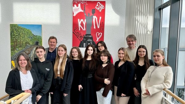 Ausstellungseröffnung im Berufskolleg: (von links) Lehrerin Ina Fabisch, Mariia Serhiienko, Schulleiter Dr. Jörg Weber, Solomiia Neskorodzhena, Daryna Yenich, Veronika Zhalnina, Viktoriia Yatsun, Veronika Furmanova, Violanta Dercho, Künstler Axel Plöger, Emily Lange und Diana Shink. - © Dietrich-Bonhoeffer-Berufskolleg