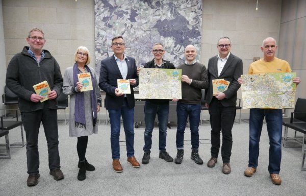 Schulsozialarbeiter Ekkehardt Loch (von links), Abteilungsleiterin Sigrun Düe, Geschäftsbereichsleiter Thomas Portong, Illustrator Andi Wolff, Designer Martin Emrich, Bürgermeister Markus Baier und Sven Neese vom AWO-Stadtteiltreff Biesterberg freuen sich über den neuen Kinderstadtplan. - © Alte Hansestadt Lemgo