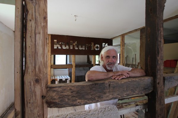Guido Weikert will in einem alten Bruchstein-Fachwerkhaus in Humfeld ein "Kulturloft" einrichten und sich gleichzeitig dem "bedingungslosen Geben" widmen. Im Hintergrund sind ein Klavier und eine improvisierte Bühne zu sehen. - © Jens Rademacher