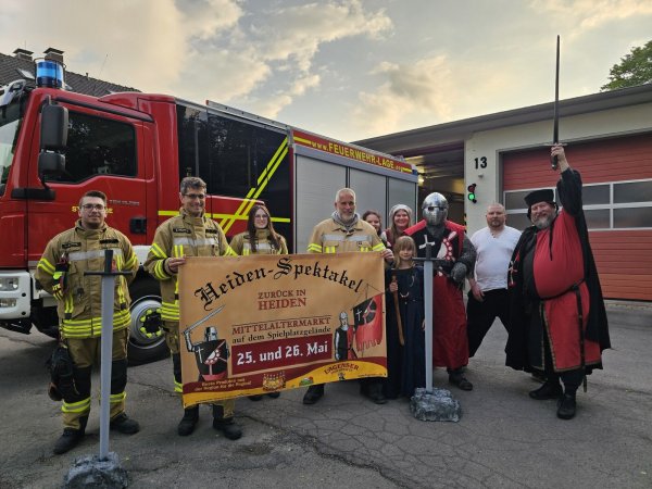 Die Einheit Heiden der Feuerwehr und der Verein Heiden Spektakel laden zum Mittelaltermarkt ein. Luca Pohl (von links), Stefan Francke, Samira Brinkmann, Carsten Drewes, Sabine Rosin, Chantal Blümel, Bastian Blümel, Christian Schlüter und Kai-Jörn Rosin freuen sich auf ein großartiges Spektakel. Kinder sind herzlich willkommen - neben dem Ritter am Eintritts-Schwertmaß steht Lienchen Baroness von Heiden. - © Astrid Sewing
