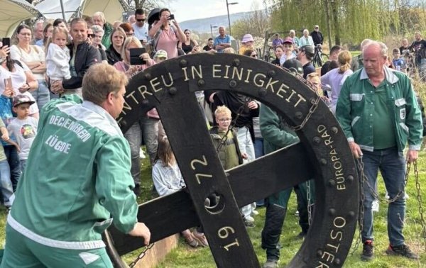 Die Dechen rollen die sechs Osterräder nacheinander in die Emmer. - © Osterdechenverein Lügde