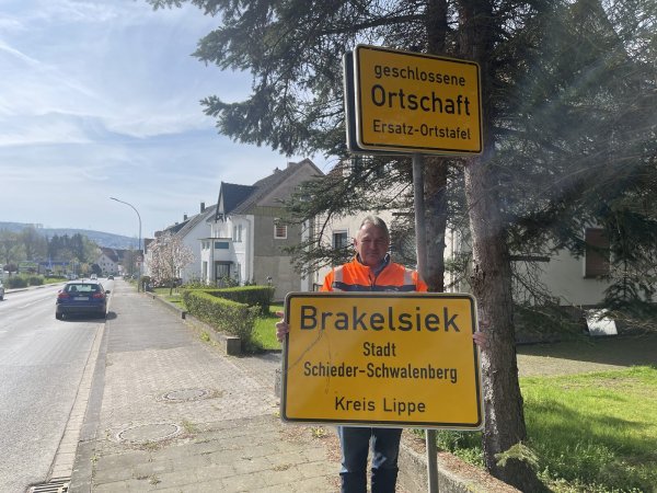 Randolf Büscher, Leiter der Straßenmeisterei in Schieder, freut sich, dass die Diebe das Schild wieder an den Tatort zurückgebracht haben. Nun wird es direkt wieder am Ortseingang von Brakelsiek montiert, auch wenn es einige Macken hat. - © Silke Buhrmester