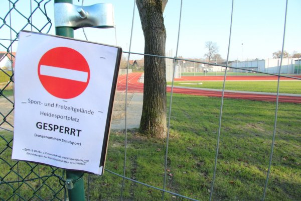 Der Heidesportplatz ist wegen der Corona-Beschränkungen geschlossen und mit Bauzaun-Elementen abgesperrt. Nur die Real- und Grundschule dürfen ihn für den Schulsport nutzen. Ein großes Schlupfloch im im noch verbliebenen Stück Maschendrahtzaun in der Westecke ermöglicht aber ungehinderten Zugang. - © Dieter Asbrock