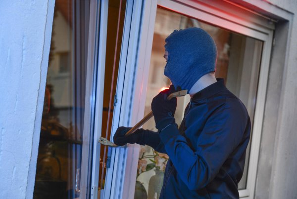 Ein Einbrecher macht sich an einem Fenster zu schaffen. (Symbolbild) - © picture alliance / picture alliance/Bildagentur-online