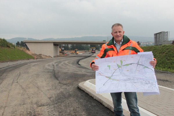 Projektleiter Dietmar Stölting erläutert die Pläne für die Barntruper Ortsumgehung. Im Hintergrund ist die Brücke zu sehen, die den VErkehr der B66n einmal über die Extertalstraße (L758) leitet. - © Carolin Brokmann-Förster