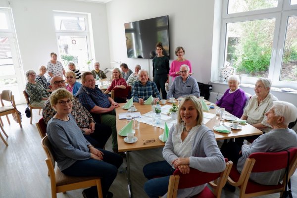 Koordinatorin Adelheid Schütte (vorne Mitte) freut sich, dass viele Besucherinnen und Besucher vom Café Pause und der Selbsthilfegruppe pflegender Angehöriger zu der Jubiläumsfeier im Mehrgenerationenhaus gekommen sind. - © Lorraine Brinkmann