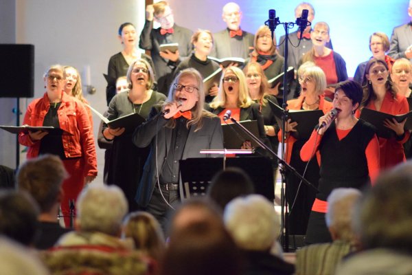 Der in Schwarz und Rot gekleidete Projektchor Leopoldshöhe hat ein Programm mit bekannten und neuen Liedern einstudiert. Immer wieder singen Solisten. Foto: Karin Prignitz - © Karin Prignitz