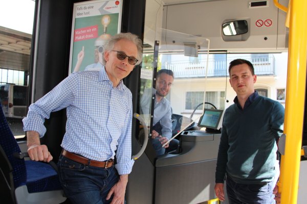 Dennis Weber sitzt hinter der neu installierten Trennscheibe im Bus. Künftig sollen die Fahrgäste wieder vorne einsteigen. Dort kann bezahlt oder das elektronische Ticket ausgelesen werden. Busunternehmer Willi Wellhausen (links) und Kevin Schulz sind gespannt, ob alles reibungslos klappt, wenn wieder mehr Fahrgäste einsteigen. - © Astrid Sewing