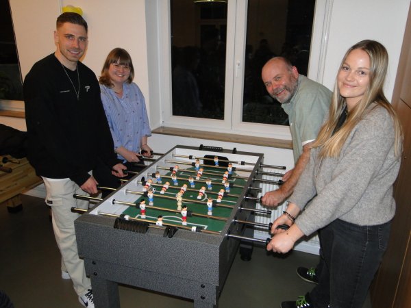 Profi-Fußballer Felix Platte vom SC Paderborn 07 stellt sich für ein aussagekräftiges Publikum gern an den Kicker des SOS-Kinderdorfes mit dem Leitungteam Laura Hesse, Holger Busch und Gillian König (von links). - © Hajo Gärtner