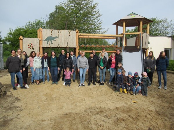 Kinder, Eltern und Mitarbeitende der Kindertageseinrichtung am Weidenbusch freuen sich über den neuen Kletterturm auf dem Außengelände. - © Kita am Weidenbusch