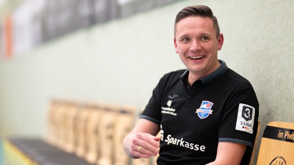 Für das Foto hat Andreas Blüsse, Geschäftsführer des Team HandbALL, direkt am Spielfeldrand Platz genommen. - © Egon Penner