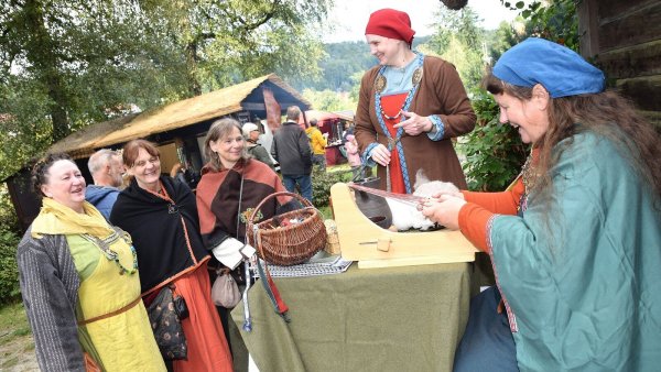 Silvia Ungerechts zeigt Besucherinnen, wie das Brettchenweben funktioniert. In einem Körbchen liegen wikingerzeitliche Borten. - © Karin Prignitz