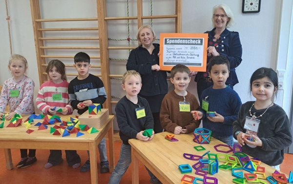 Stellvertretende Kita-Leiterin Margarita Wiebe (hinten links) freut sich mit den Kindern über die Förderung der Osthushenrich-Stiftung, überreicht durch Geschäftsführerin Claudia Holle. - © Stadt Lemgo