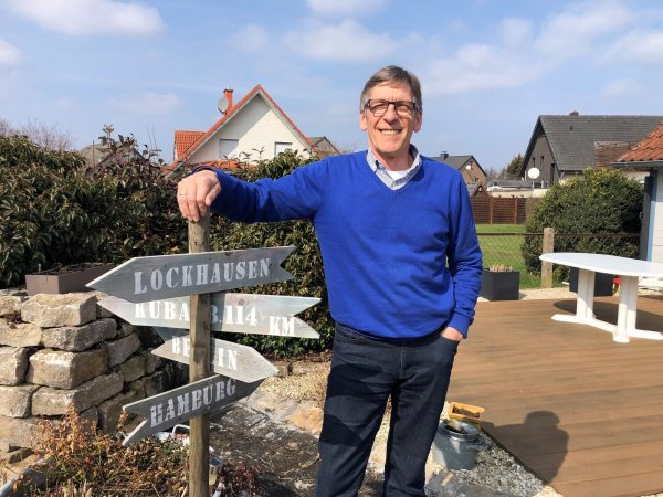 Michael Meier steht in seinem Garten am selbstgebauten Wegweiser. In Berlin und Hamburg leben seine Kinder, nach Kuba ging die Hochzeitsreise mit seiner Frau, in Lockhausen ist er zuhause. - © Sven Kienscherf
