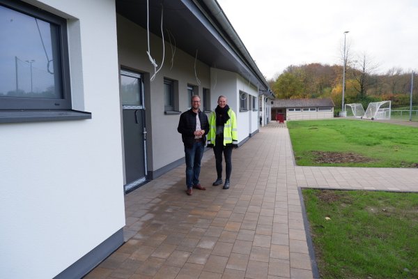 Bürgermeister Borris Ortmeier und Carina Brakhage, Teamleiterin Planen und Bauen, vor dem Neubau des Sporthauses Wolfsiek. - © Lorraine Brinkmann
