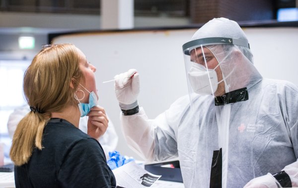 Eine Reiserückkehrerin lässt sich am Flughafen auf das Coronavirus testen. Seit Samstag müssen Einreisende aus Risikogebieten einen Abstrich machen. Anderen Urlaubern steht es frei, einen kostenlosen Test in Anspruch zu nehmen. - © Daniel Bockwoldt/dpa