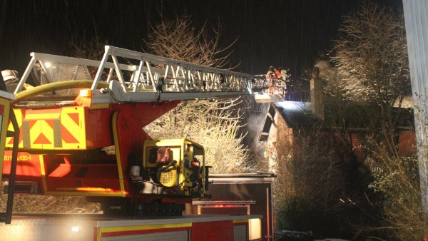 Mit Hilfe der Drehleiter der Löschgruppe Bad Salzuflen wurde das Dach des Bahngebäudes aufgenommen, um mögliche Glutnester abzulöschen. Immer wieder steigen Rauchschwaden aus dem seit Jahren verlassenen Gebäude auf. - © Feuerwehr Bad Salzuflen