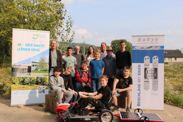 Mit dem selbst umgebauten Bobbycar: (von links) Dr. Eike Stiller (Schulleiter), Vladislav Cara (Schüler), Nils Donat (Techniklehrer), Annika Kubera (Personalmanagerin BaSys), Addy Schulze (Schulze Spezialbau), Adam Otto, Djego Pönitzsch, Marko Glombitza, Ben Fuhrmann, Tino Zörnig, Jan Henrich, Eike Schmidtpott und Ben Rademache (alle acht Schüler). - © Chiara Wibbeke