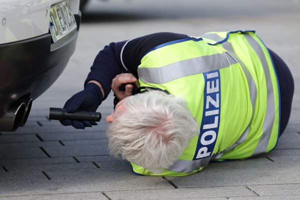 Ein Polizist leuchtet bei einem Tuner- und Poser-Treffen am „Car-Freitag“ mit einer Taschenlampe in den Auspuff eines Fahrzeuges. - © David Young/dpa