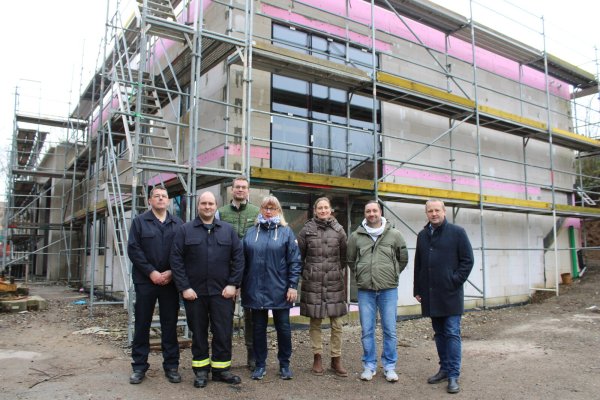 Michael Little (stv. Leiter Feuerwehr Kalletal, von links), Andreas Wagner (Löschgruppenführer Talle), Simon Prüßner (SPD-Ratsmitglied), Brigitte Lähnemann (UKB-Ratsmitglied), Architektin Wera Binder, Nikolai Stoll (Fachbereich Planen und Bauen) und Bürgermeister Mario Hecker vor dem Neubau des Feuerwehrgerätehauses in Talle. - © Lorraine Brinkmann