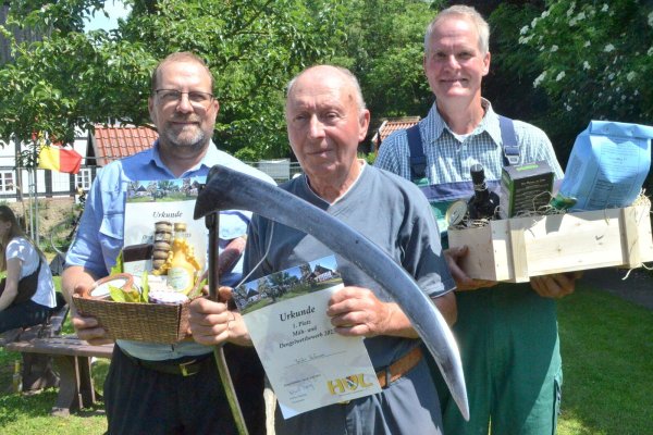 Thomas (dritter Platz, v. l.) und sein Vater Baldur Hafemann (Sieger) zählten zu den Besten beim Mäh- und Dengelwettbewerb. Auf den zweiten Platz kam Jürgen Sonnenberg. Foto: Sibylle Kemna - © Sibylle Kemna