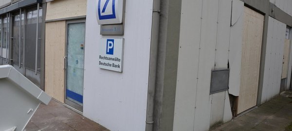 Die Selbstbedienungsfiliale der Deutschen Bank ist nach der Sprengung des Geldautomaten erst einmal mit Holzplatten gesichert. - © Karin Prignitz