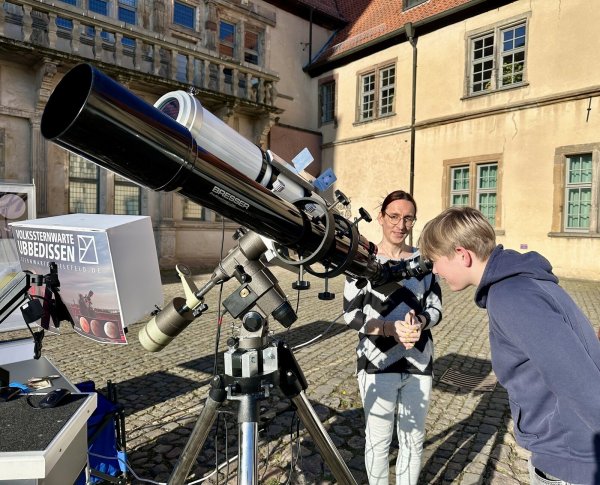 Einen gefahrlosen Blick auf die Sonne zu werfen, ist faszinierend. Bente Kähler (links), Leiter der Volkssternwarte Ubbedissen, erklärt dem 14-jährigen Julius, warum die Sonne Flecken hat. - © Weserrenaissance-Museum Schloss Brake
