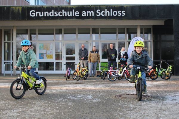 Die Erstkässler Osama (links) und Ole testen die neuen gespendeten Fahrräder. - © Annika Langhagel