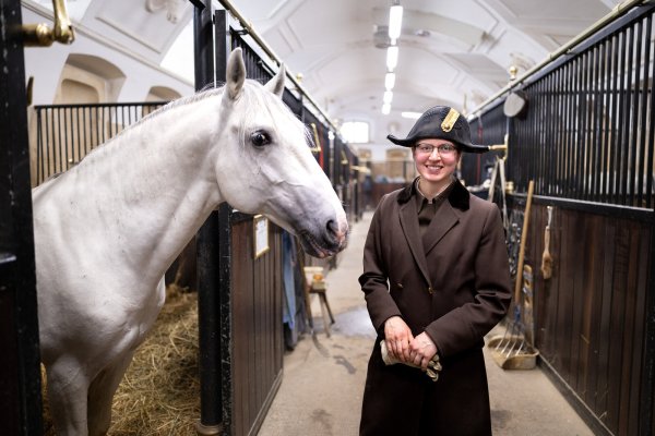 Bereiteranwärterin Paula Behrens, die aus Paderborn stammt, steht mit Lipizzaner-Hengst Neopolitana Brava II in der Stallburg der Spanischen Hofreitschule. - © Niklas Tüns