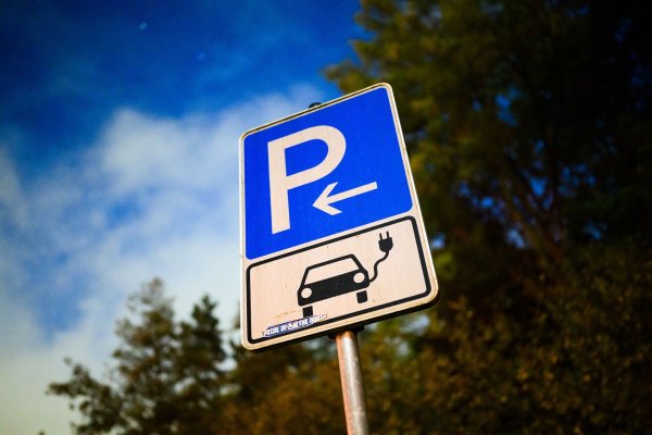 Ein Schild markiert einen Parkplatz für ein Elektroauto an einer öffentlichen Schnellladesäule. - © Julian Stratenschulte/dpa