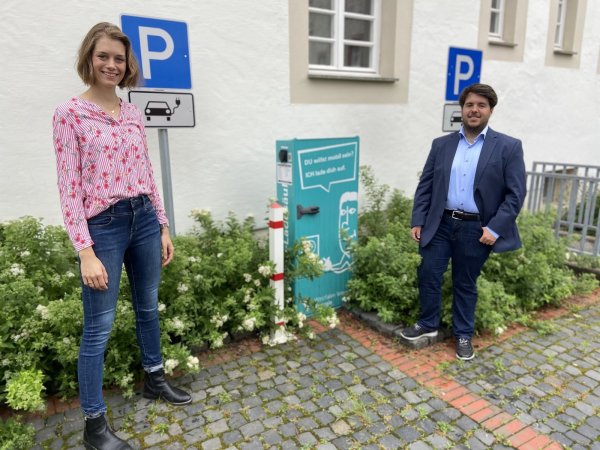 SPD-Ratsfrau Hannah Penke posiert mit dem Bürgermeisterkandidaten der Sozialdemokraten, Julian Koch, vor der Ladestation am Rathaus. - © SPD Schlangen