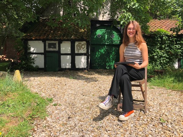 Lina Meier sitzt mit dem Tablet, den jedes Ratsmitglied von der Stadt bekommt, vor dem Kotten neben dem Wohnhaus, in dem sie lebt. Foto: Sven Kienscherf - © Sven Kienscherf