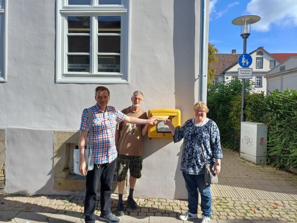 Die Mitglieder des Werkstattrats, Olaf Wegemann, Michael Mehltretter und Gaby Flügge-Quent (von links), werfen die Unterschriften in einen Briefkasten ein. - © Lebenshilfe Detmold