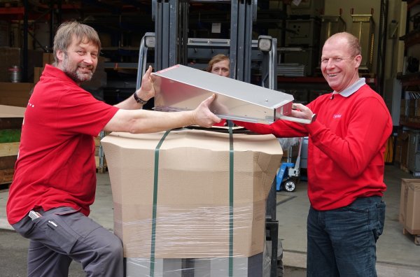 Der „Pelletomat" ist Beschäftigungsmaterial aus Metall für Schweine. Dirk Grenner (links) und Dirk Huxol (rechts) laden ab, was Dennis Bünte ins Lager fährt. - © Axel Bürger(LZ)