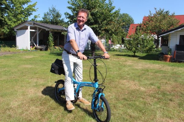 Das blaue Faltrad ist zu seinem Markenzeichen geworden: Gerne fährt Bodo Kibgies mit dem Rad durch die Sennegemeinde und kommt dabei mit den Menschen ins Gespräch.  - © Michaela Weiße