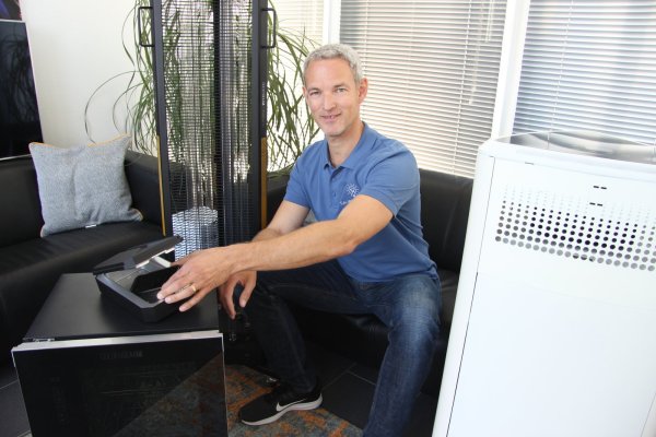 Michael Althaus, Geschäftsführer von Aryton Lighting hat Alternativen zu flüssigen Desinfektionsmitteln. Die Technik basiert auf UV-C-Strahlen. Fünf Minuten das Smartphone in die Box gelegt und sauber ist es. Die Firma bietet auch Luftreiniger an. - © Kirsten Fuhrmann