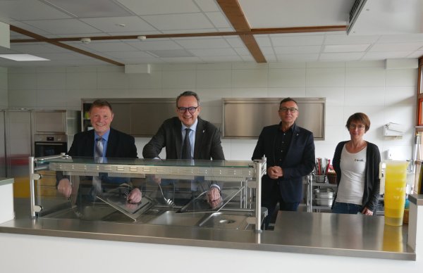 Schulamtsdirektor Torsten Buncher und Bürgermeister Markus Baier legen schon selbst Hand an in der neuen Mensa der Südschule. Auch Geschäftsbereichsleiter Thomas Portong und Schulleiterin Christiane Beermann von links) freuen sich. - © Stadt Lemgo