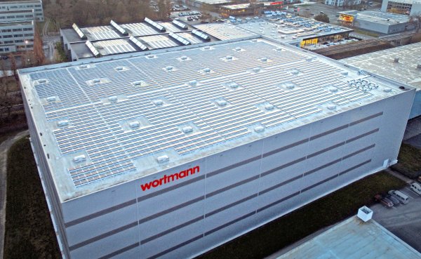 Das Hochregallager mit Photovoltaik-Anlage (im Vordergrund) und die Hauptverwaltung mit Outlet (im Hintergrund).  - © Wortmann Schuh-Holding