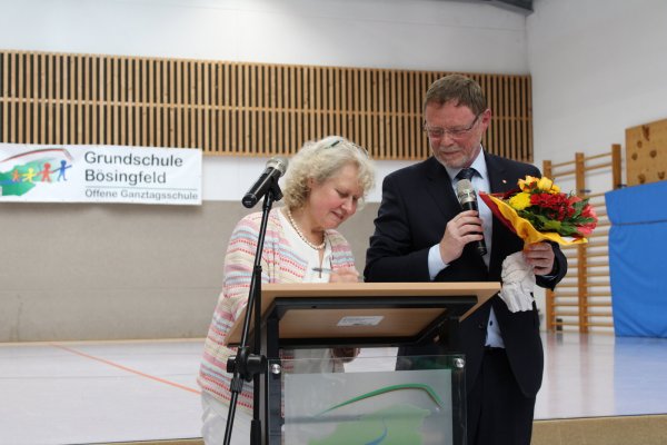 Mit ihrer Unterschrift ist es besiegelt: Silvia Genat verlässt nach 14 Jahren die Grundschule Bösingfeld. Von Schulamtsdirektor Torsten Buncher gibt es ein Grußwort und Blumen zum Dank. - © Lorraine Brinkmann