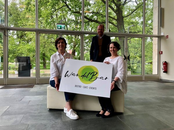 Kerstin Baus (links), Volker Stammer und Simone Rasche zeigen in der Wandelhalle das Logo der „WandelBar“. Foto: Sven Kienscherf - © Sven Kienscherf
