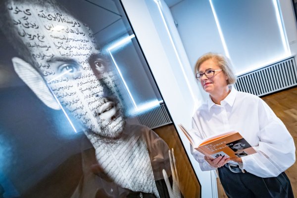 Kuratorin Christiane Heuwinkel blickt auf Shirin Neshats Foto Ibrahim, in dem Bild und Schrift vereint sind. Foto: Sarah Jonek - © Sarah Jonek Fotografie