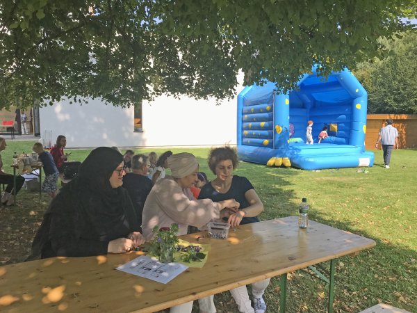 Gemütlich unterm Baum ein Schwätzchen halten, während sich die Kleinen auf der Hüpfburg vergnügen: Das Fest, das der Tisch und der Mittagstisch gemeinsam ausgerichtet haben, ist gut angekommen. - © Claudia Theis