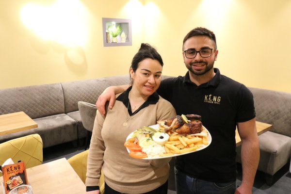Samia Chaer und ihr Bruder Ibrahim mit einem gegrillten Hähnchen in ihrem Lokal "King Chicken Grill". - © Alexandra Schaller