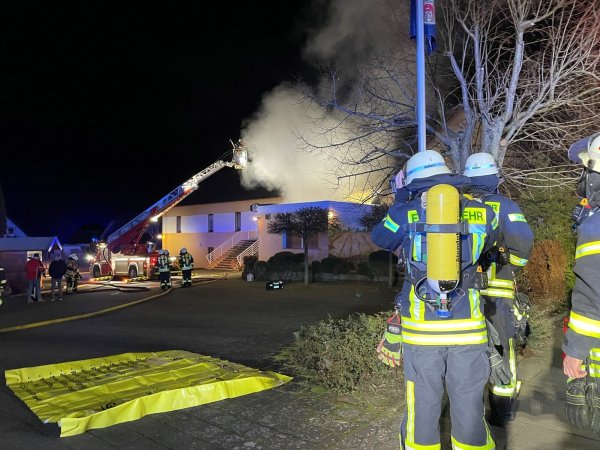 Mehrere Trupps unter schwerem Atemschutz stehen vor der noch brennenden Gaststätte im Bad Salzufler Ortsteil Retzen und warten auf ihren Einsatz. Durch das schnelle Eingreifen konnten Wohnhaus und Saal gehalten werden. - © Foto: Daniel Hobein / Feuerwehr Bad Salzuflen