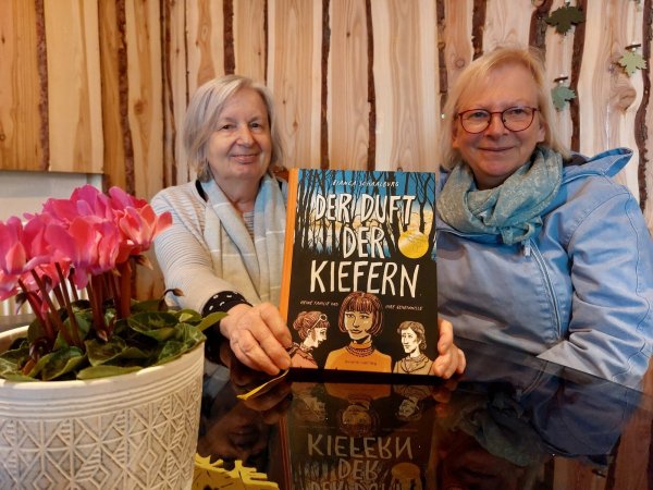 Annegret Kulms (links) und Bettina Hanke-Postma gehören zu dem Arbeitskreis, der sich in Schwalenberg um die Verlegung der Stolpersteine kümmert. Sie weisen auf die Lesung von Bianca Schaalburg aus ihrem Buch "Der Duft der Kiefern" hin. - © Michaela Weiße