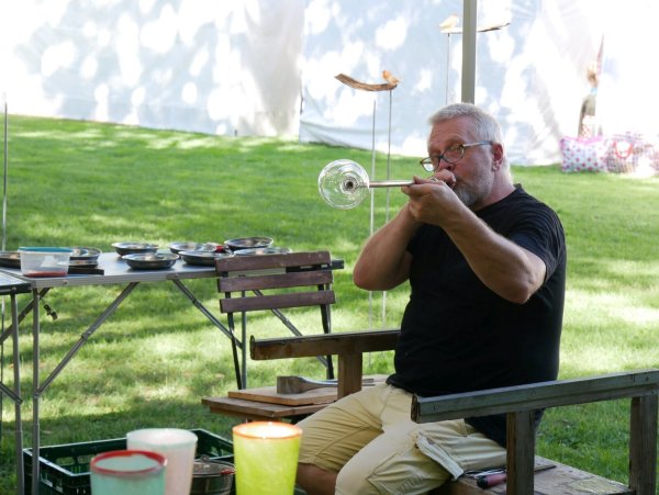 Glasbläser Hans Harder aus Petershagen ist neu auf dem Detmolder Kunstmarkt. Hier fertigt er am Brennofen ein Trinkglas an. - © Thomas Krügler