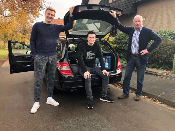 Timo und Nils Schlingmann stehen mit ihrem Großvater Peter Samland (von links) am Auto. Die beiden Brüder bieten an, für Menschen in Holzhausen-Sylbach, die zur Corona-Risikogruppe gehören, das Einkaufen zu übernehmen. - © Sven Kienscherf